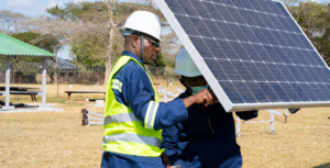 Trainee positioning a solar module during practical assessment of training of trainers by TEVETA.png